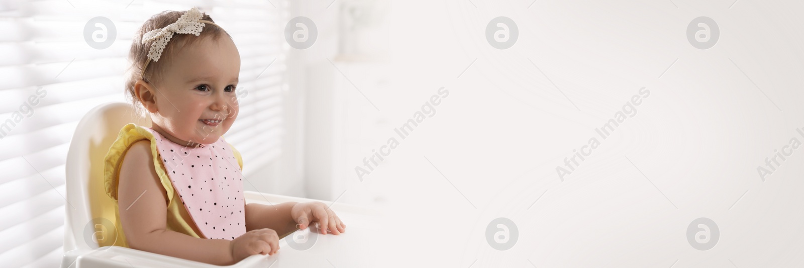 Image of Cute little baby wearing bib in highchair at home, space for text. Banner design