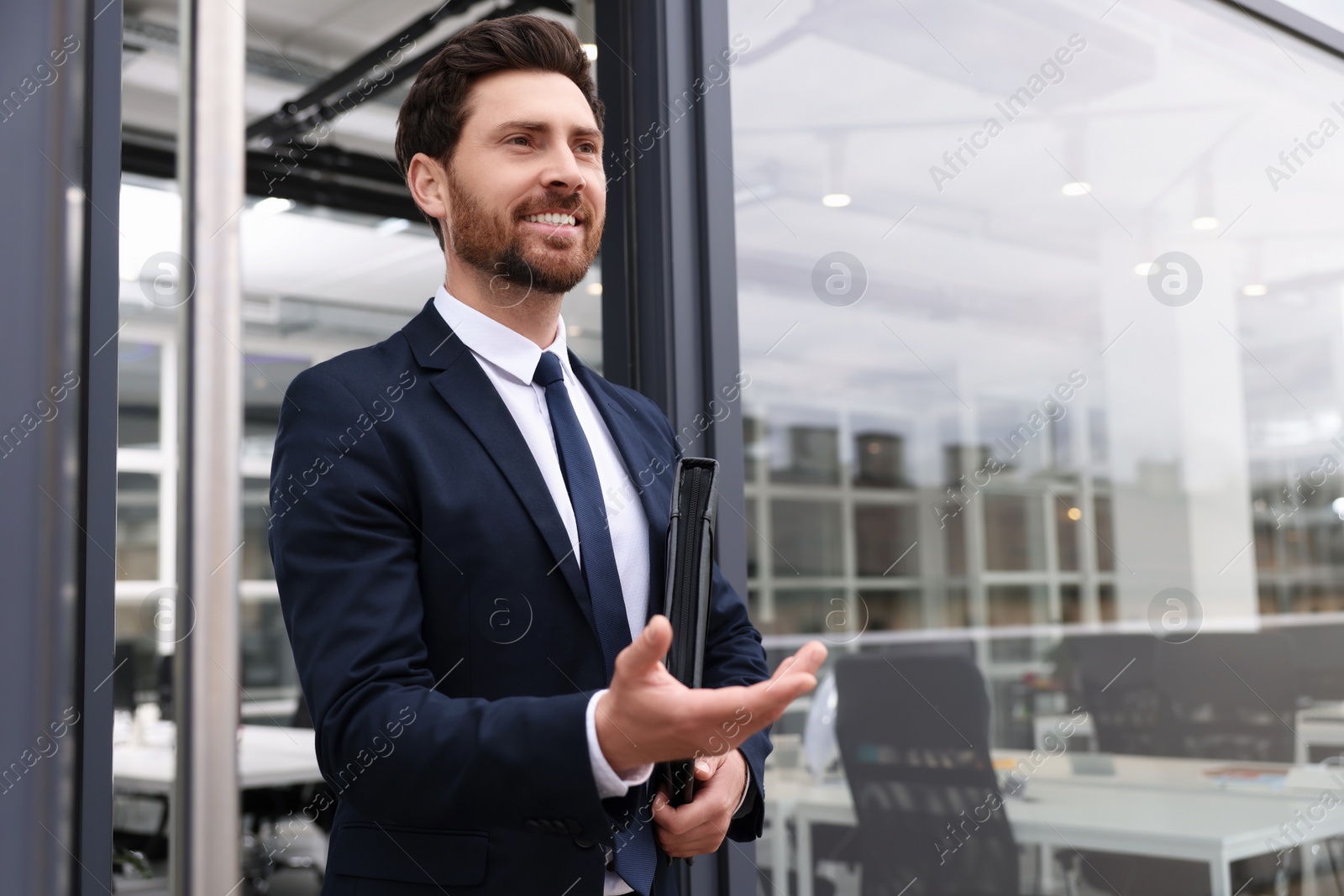 Photo of Real estate agent with leather portfolio inviting inside. Space for text