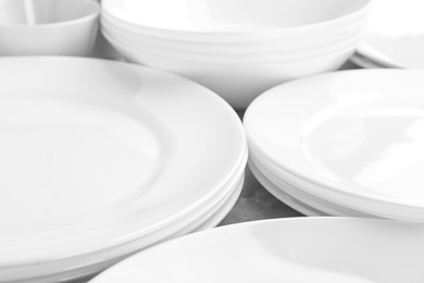 Many stacked white plates on table, closeup