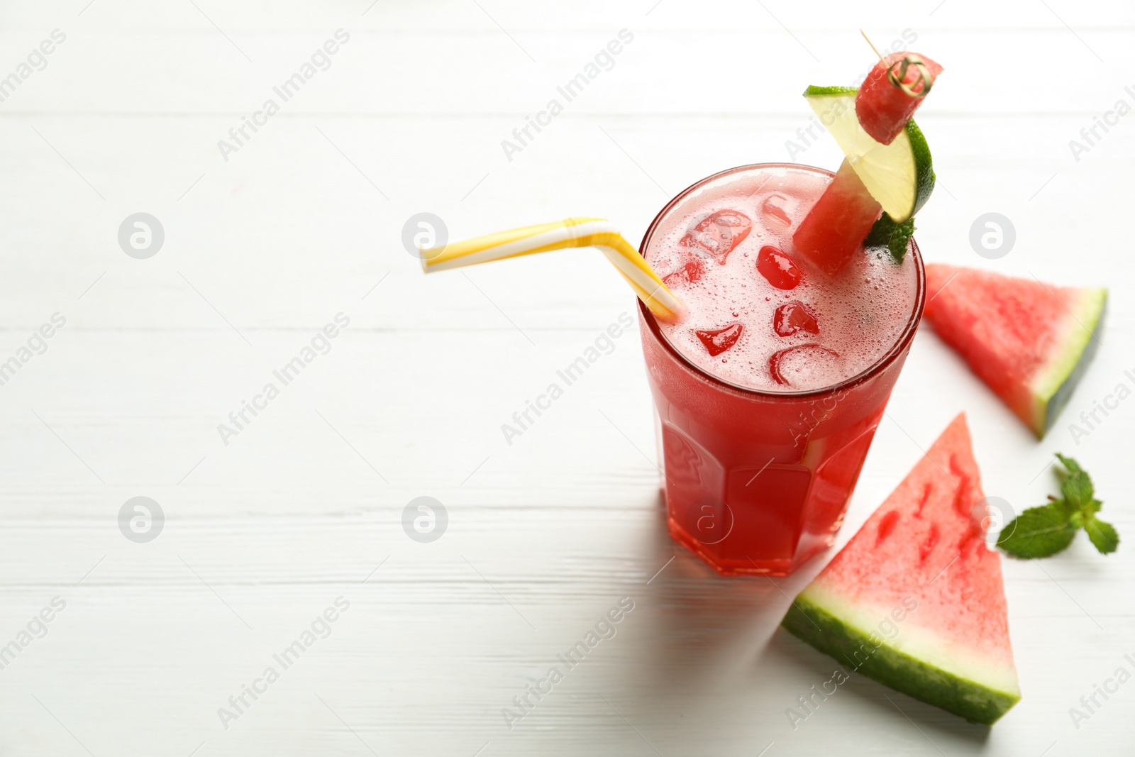 Photo of Delicious fresh watermelon drink on white wooden table. Space for text
