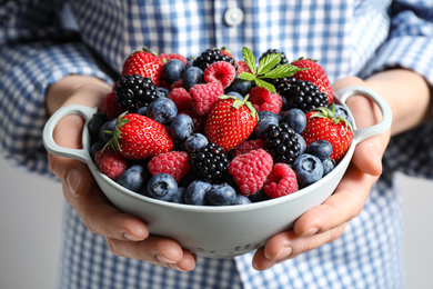 Photo of Woman with bowl of delicious summer berries, closeup