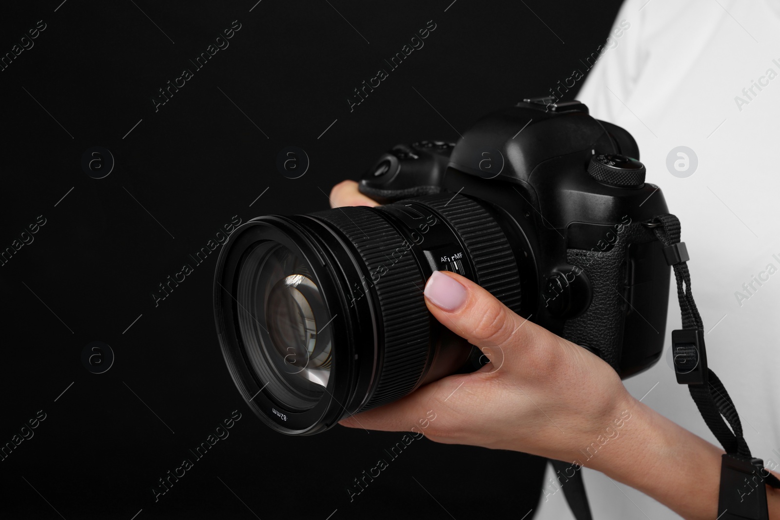 Photo of Photographer with camera on black background, closeup