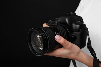 Photographer with camera on black background, closeup