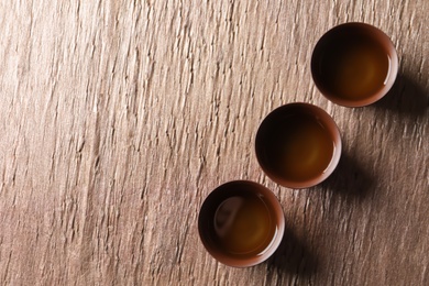 Cups of Tie Guan Yin oolong tea on table, top view with space for text