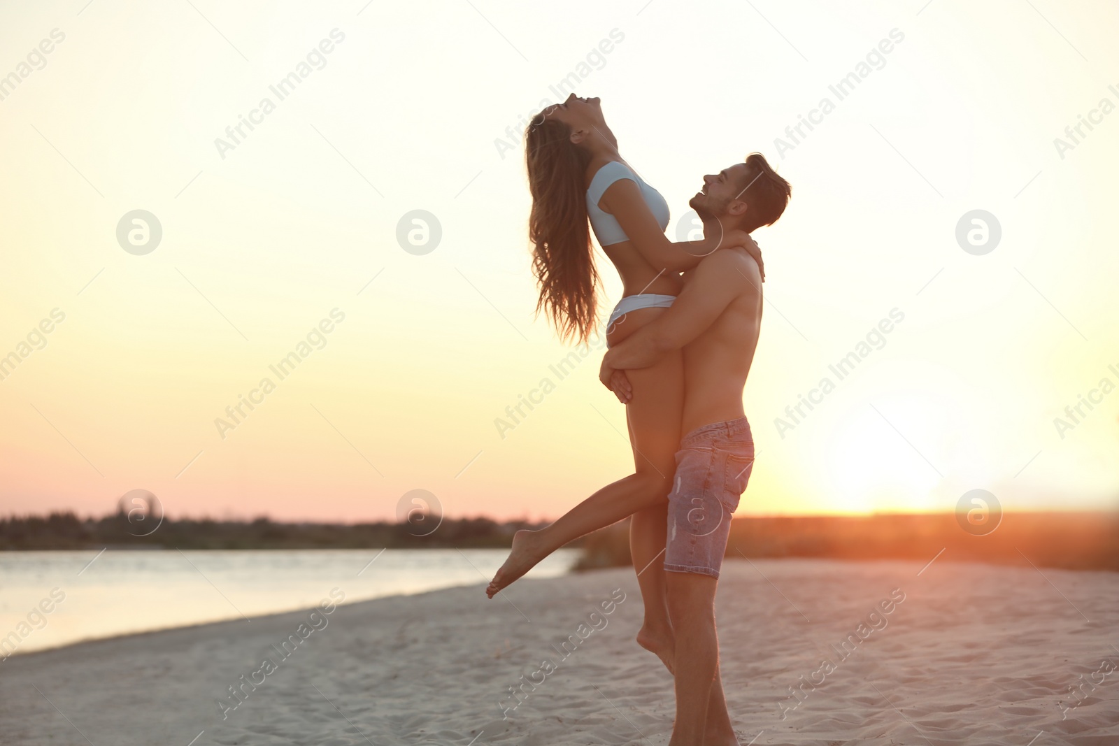 Photo of Happy young couple playing together on beach
