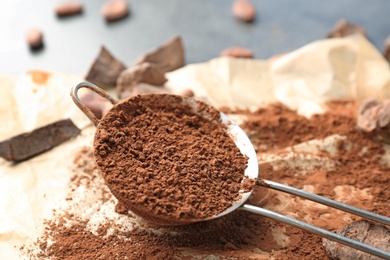 Photo of Sieve with cocoa powder on parchment