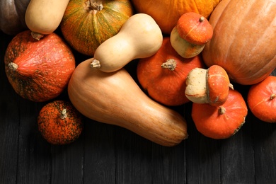 Photo of Flat lay composition with different pumpkins on wooden background. Autumn holidays