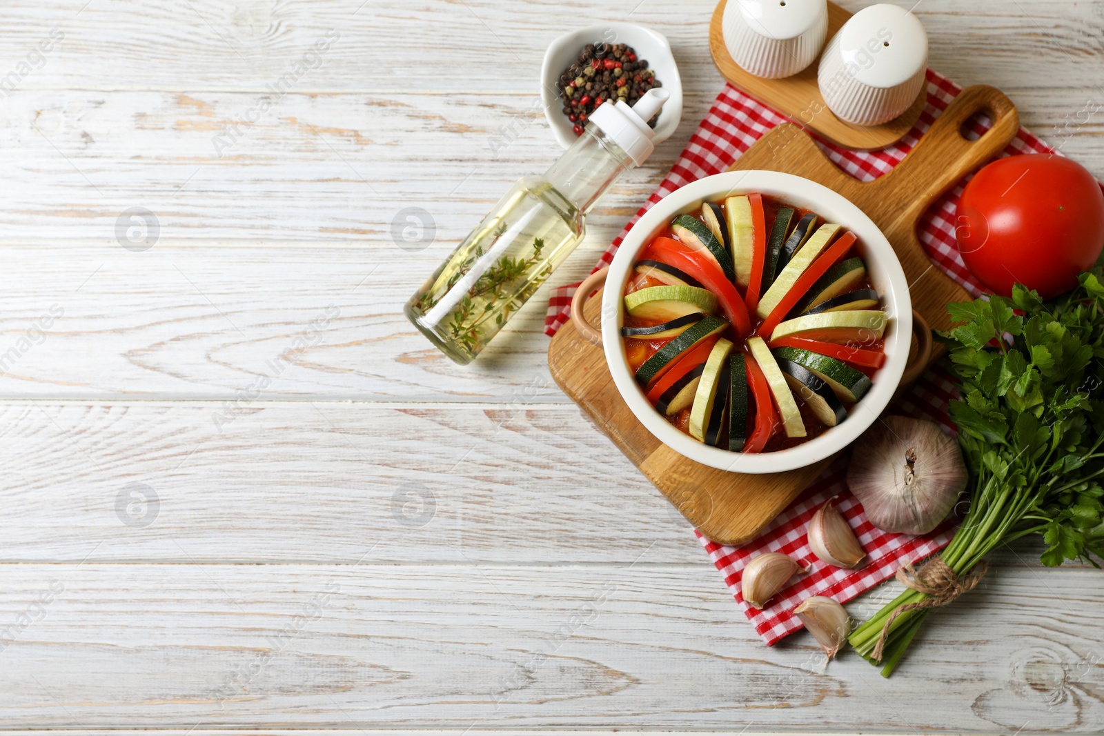 Photo of Cooking delicious ratatouille. Dish with different fresh cut vegetables on white wooden table, flat lay. Space for text