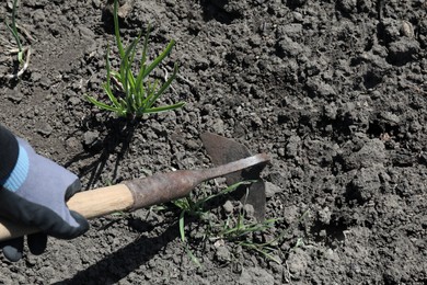 Photo of Gardener shaping soil in garden on sunny day, top view