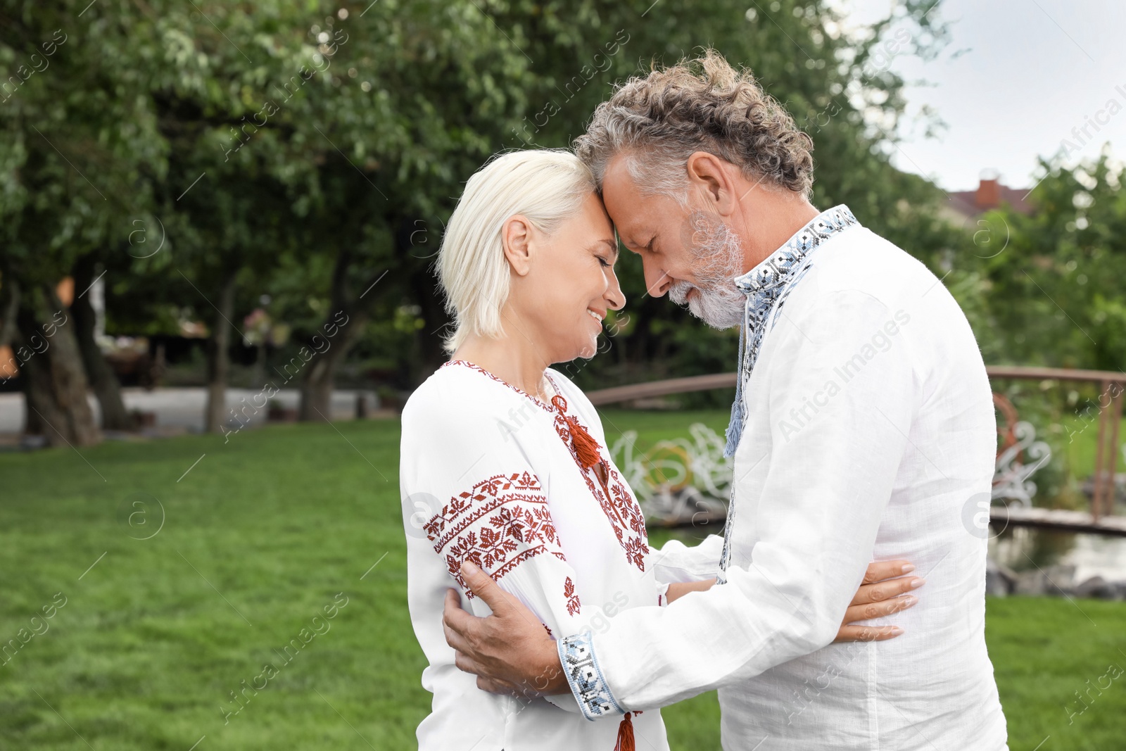 Photo of Happy mature couple in Ukrainian national clothes outdoors