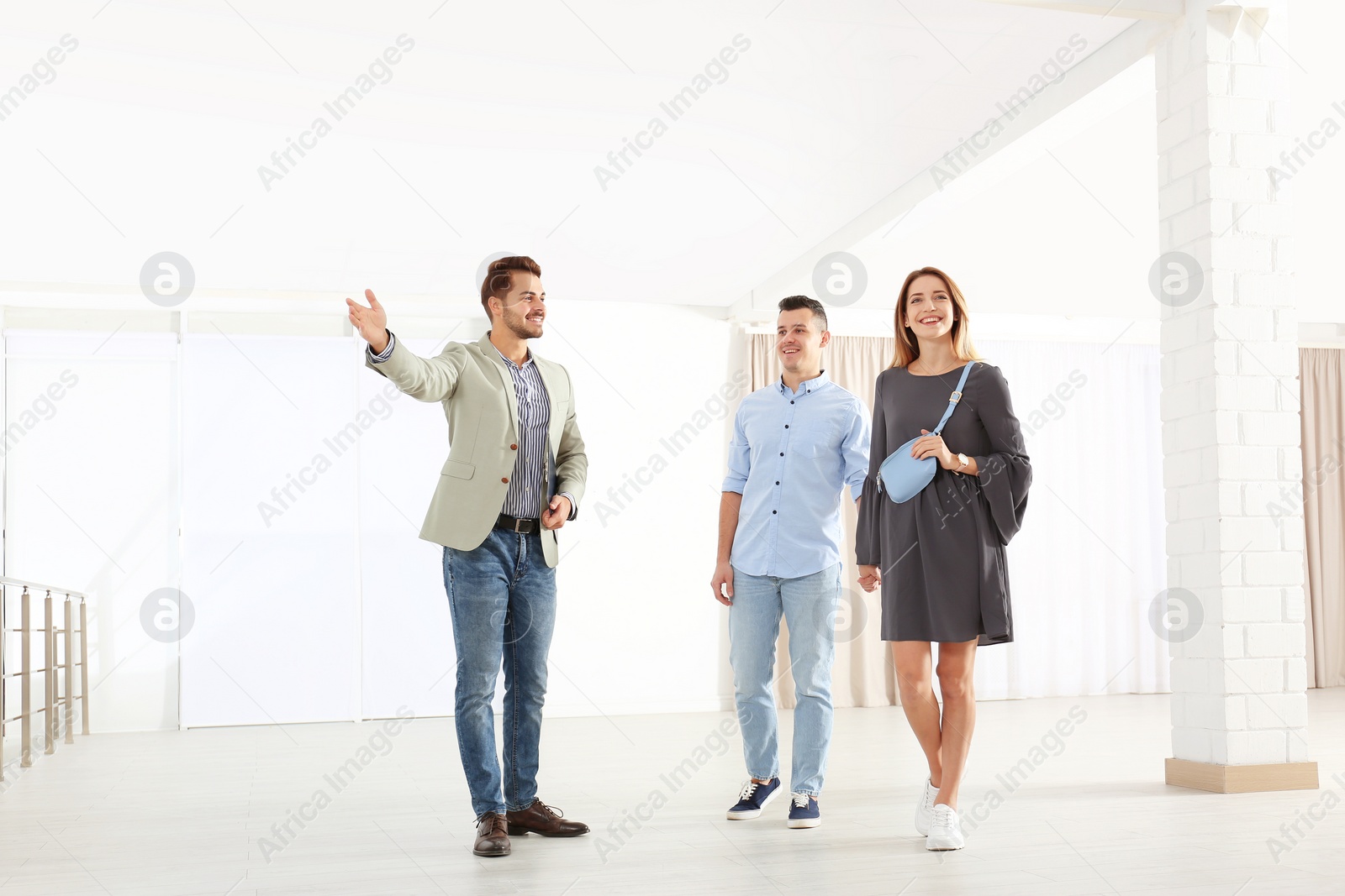 Photo of Real estate agent showing new apartment to young couple