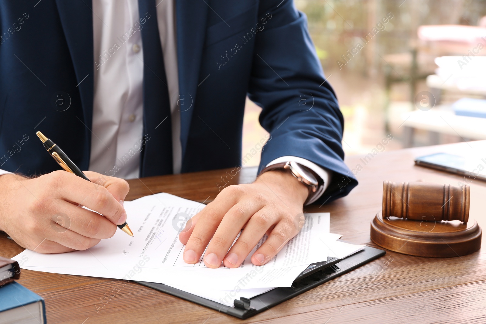 Photo of Lawyer working with documents at table, focus on hands