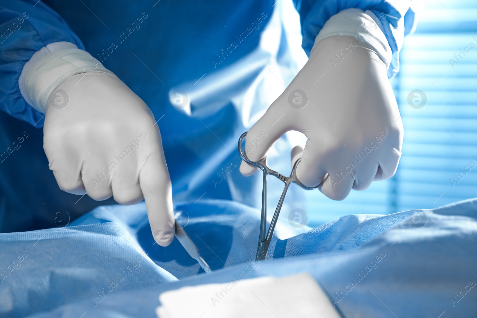 Photo of Professional surgeon with instruments performing operation in clinic, closeup