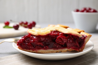 Slice of delicious fresh cherry pie on table, closeup