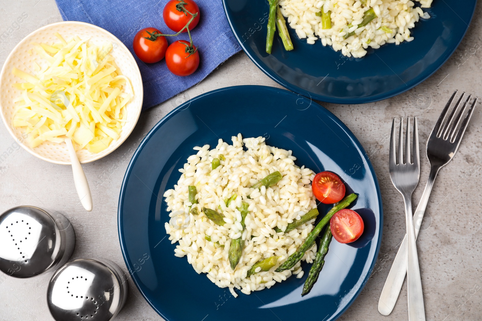 Photo of Delicious risotto with asparagus on grey table, flat lay