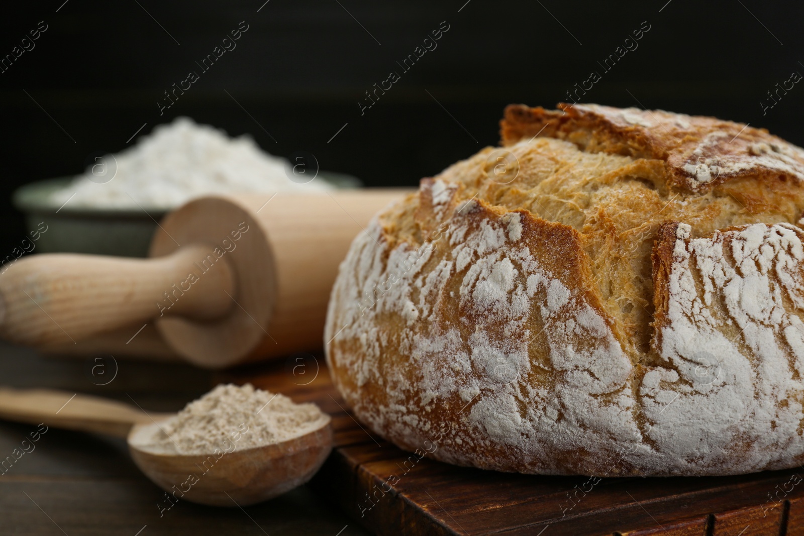 Photo of Freshly baked sourdough bread on wooden table, closeup