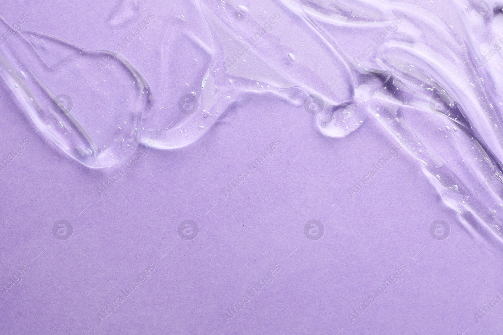 Photo of Clear cosmetic gel on violet background, top view. Space for text