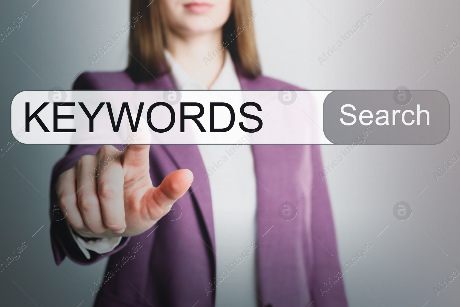 Image of Woman pointing at search bar with text KEYWORDS on light grey background, closeup