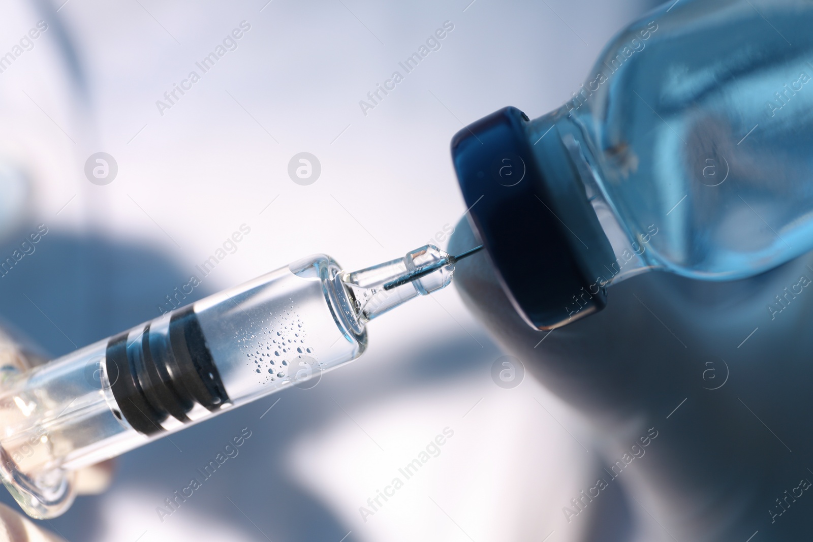 Photo of Doctor filling syringe with vaccine from vial, closeup