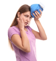 Unhappy woman using cold pack to cure headache on white background