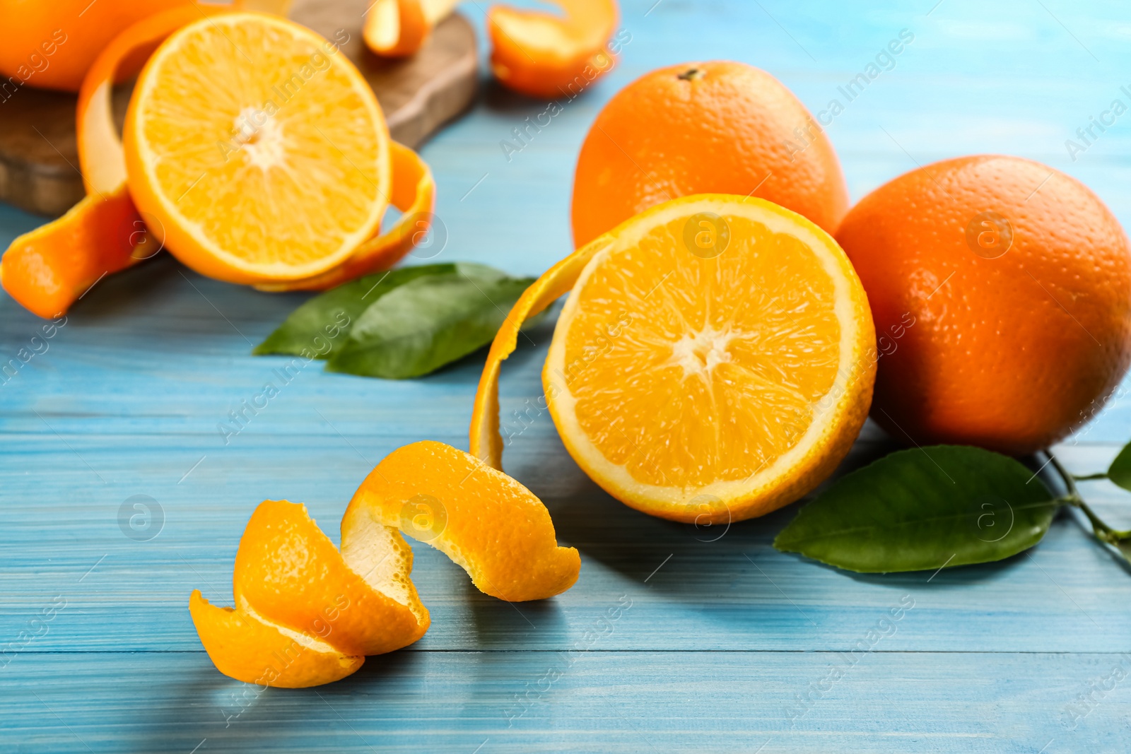 Photo of Orange fruits with peels on light blue wooden table