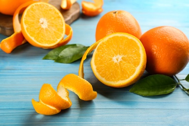 Orange fruits with peels on light blue wooden table