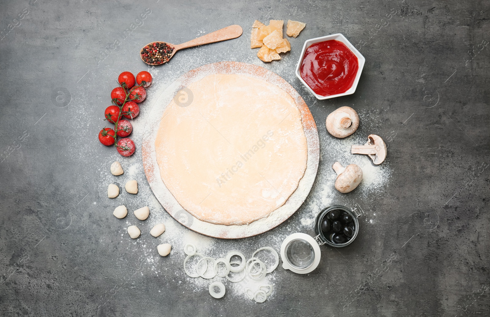 Photo of Dough and ingredients for pizza on gray background, top view