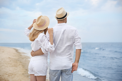 Happy couple having romantic walk on beach