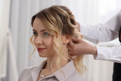 Photo of Hair styling. Professional hairdresser working with client indoors, closeup