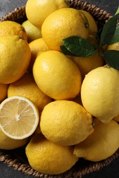 Photo of Fresh lemons in wicker basket on table, top view