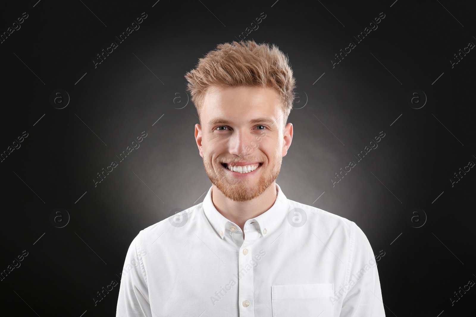 Photo of Portrait of handsome young man on dark background