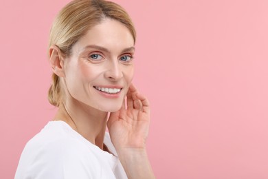 Woman with clean teeth smiling on pink background, space for text