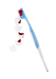 Photo of Decorative teeth and toothbrush with blood on white background, top view. Gum inflammation