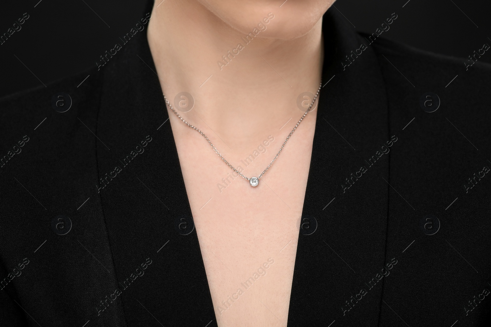 Photo of Woman with elegant necklace on black background, closeup