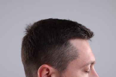 Photo of Man with healthy hair on grey background, closeup