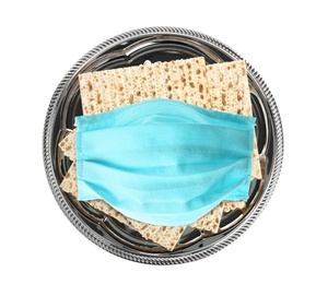 Image of Coronavirus pandemic. Passover matzos and protective face mask on white background, top view