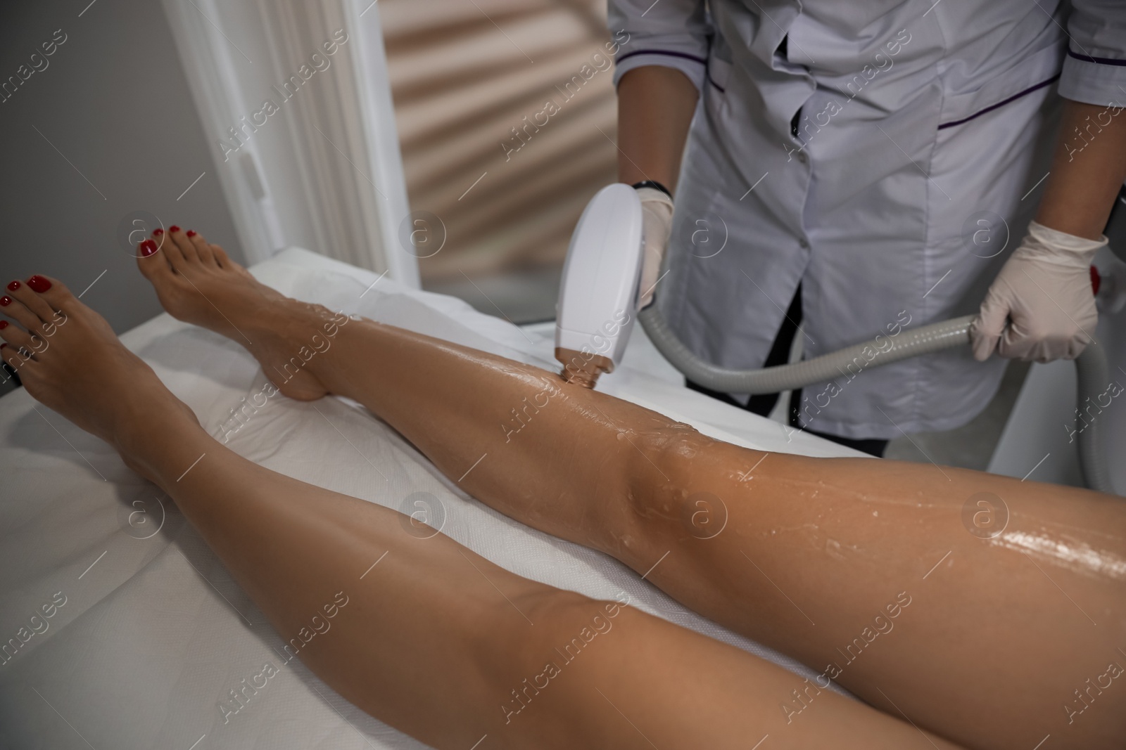 Photo of Woman undergoing laser epilation procedure in beauty salon, closeup