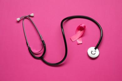 Photo of Pink ribbon and stethoscope on color background, flat lay. Breast cancer awareness