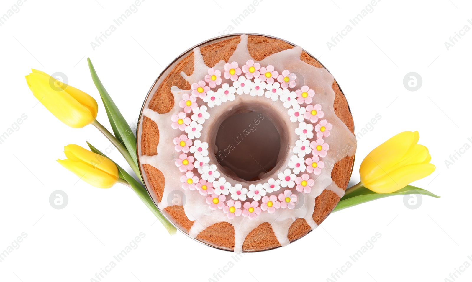 Photo of Festively decorated Easter cake and yellow tulips on white background, top view