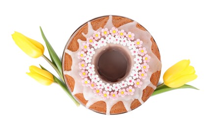 Photo of Festively decorated Easter cake and yellow tulips on white background, top view