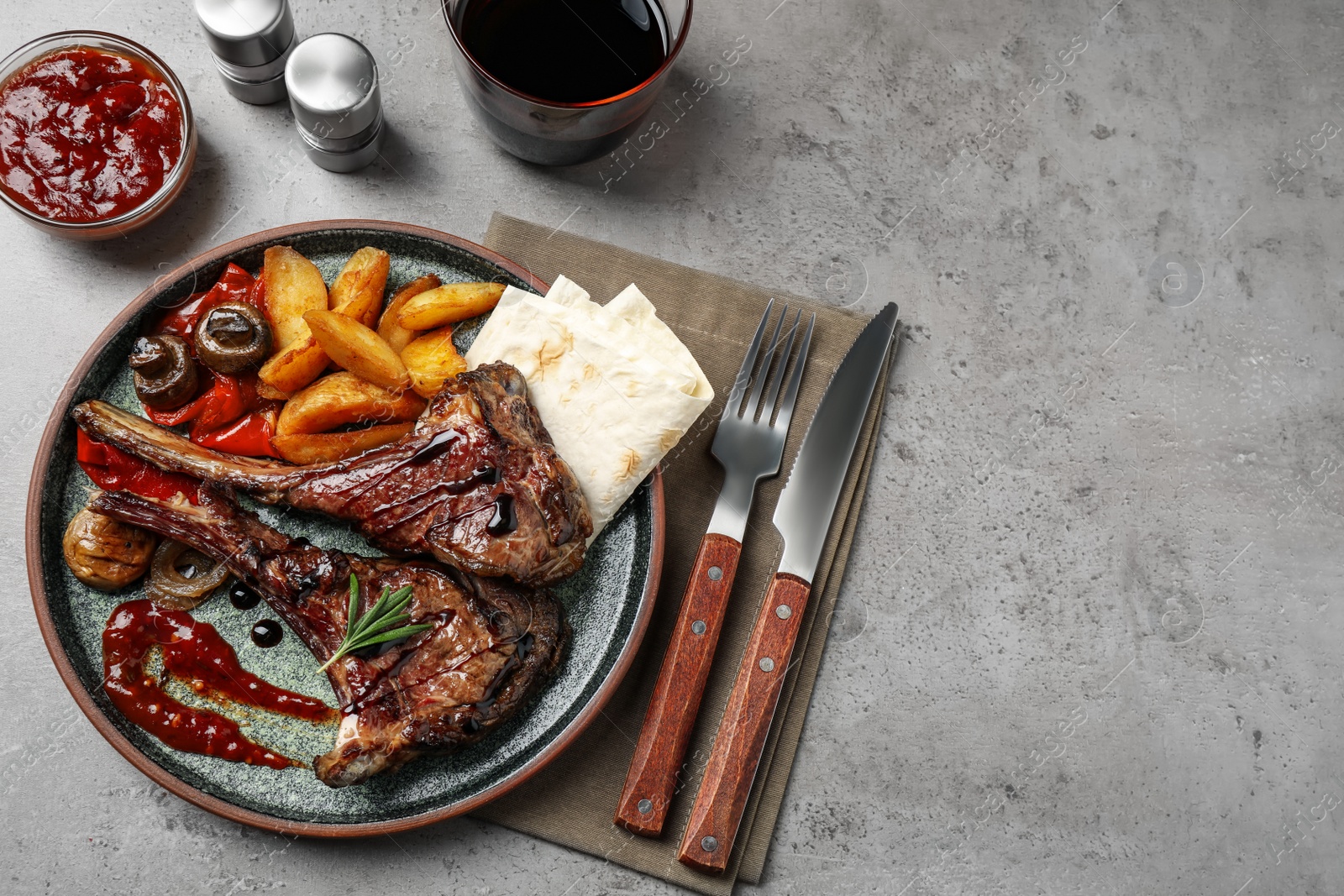 Photo of Delicious grilled ribs served on light grey table, flat lay. Space for text