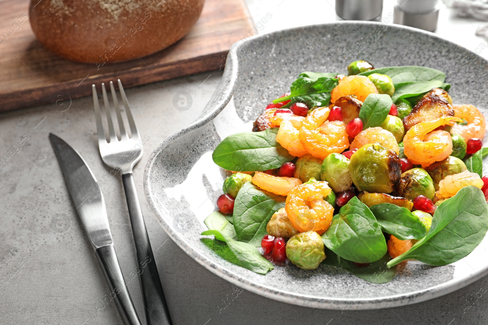 Photo of Plate of warm salad with Brussels sprouts on table