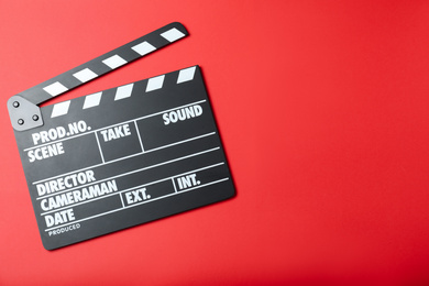 Clapper board on red background, top view with space for text. Cinema production