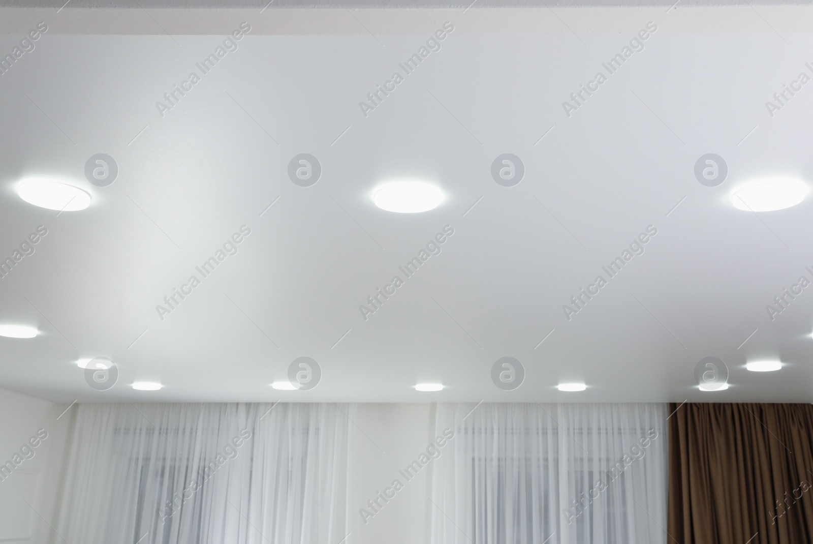 Photo of White ceiling with lamps indoors, below view