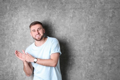 Portrait of handsome happy man on grey background, space for text