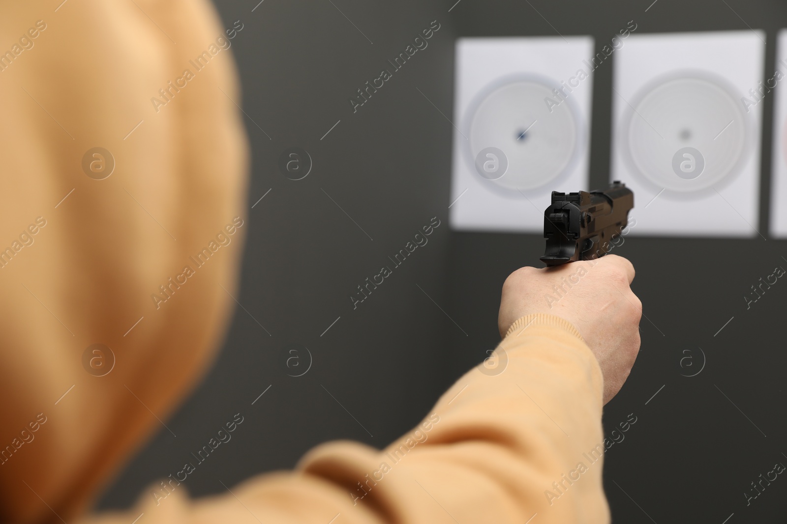 Photo of Man aiming at shooting target indoors, closeup