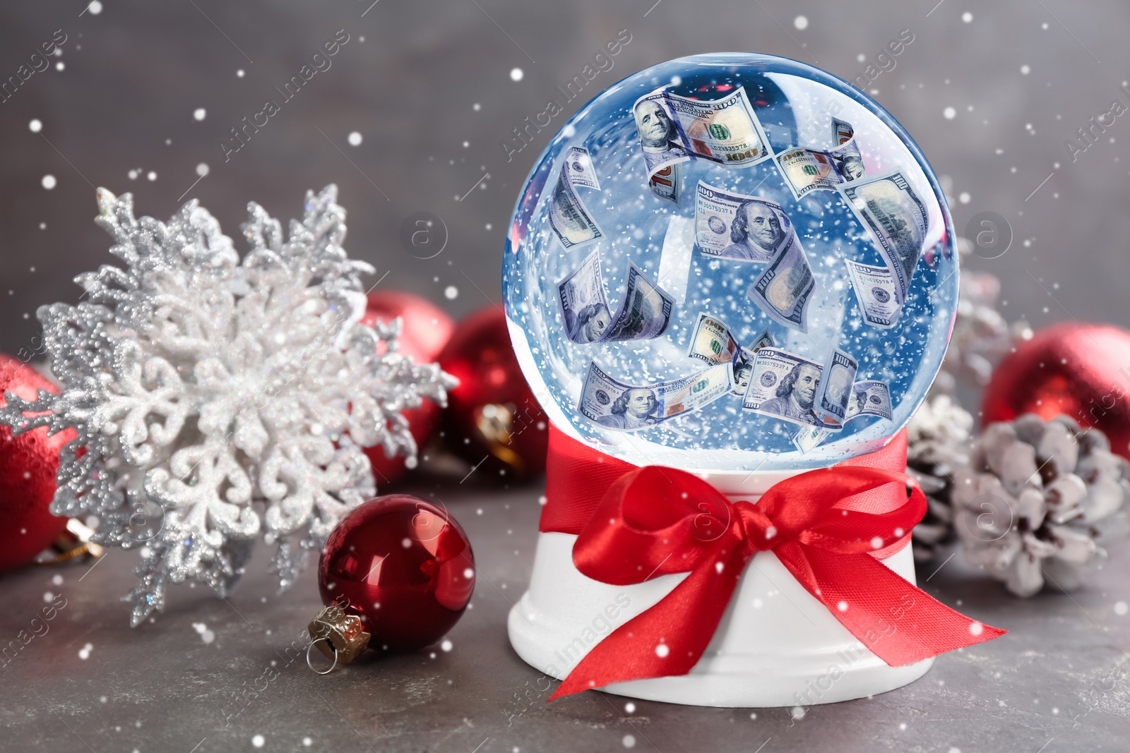 Image of Snow globe with dollar banknotes and Christmas decor on table