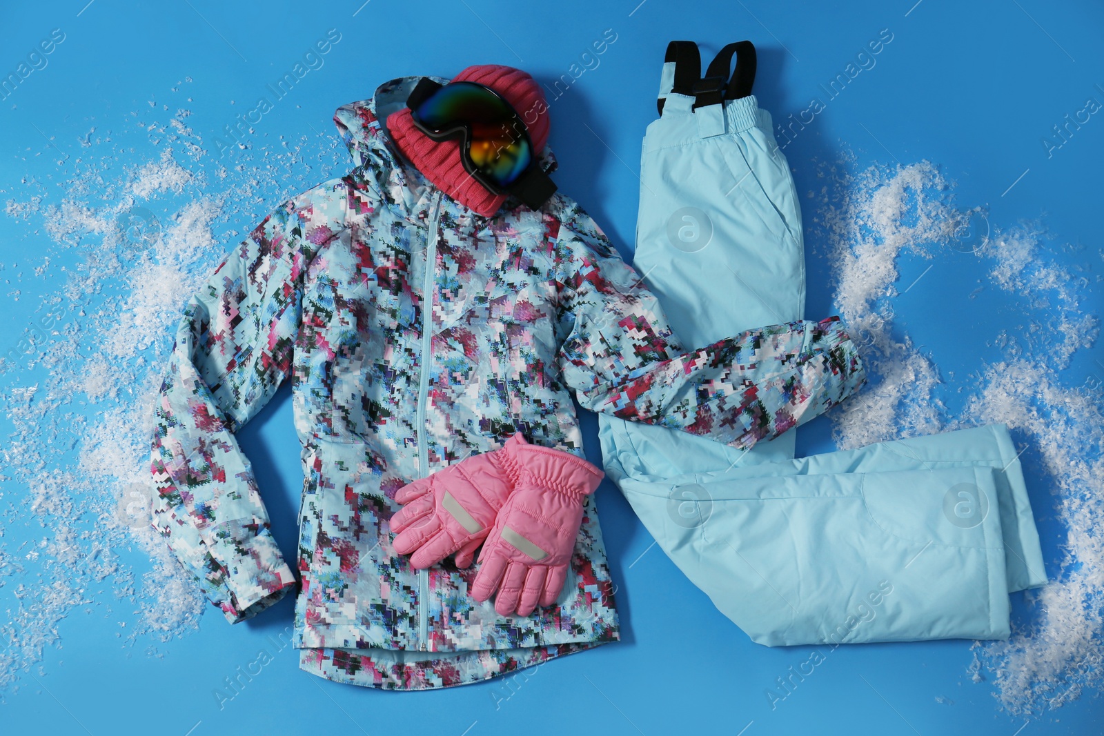 Photo of Stylish winter sport clothes on light blue background, flat lay