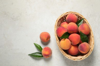 Photo of Fresh peaches and leaves on light textured table, flat lay. Space for text
