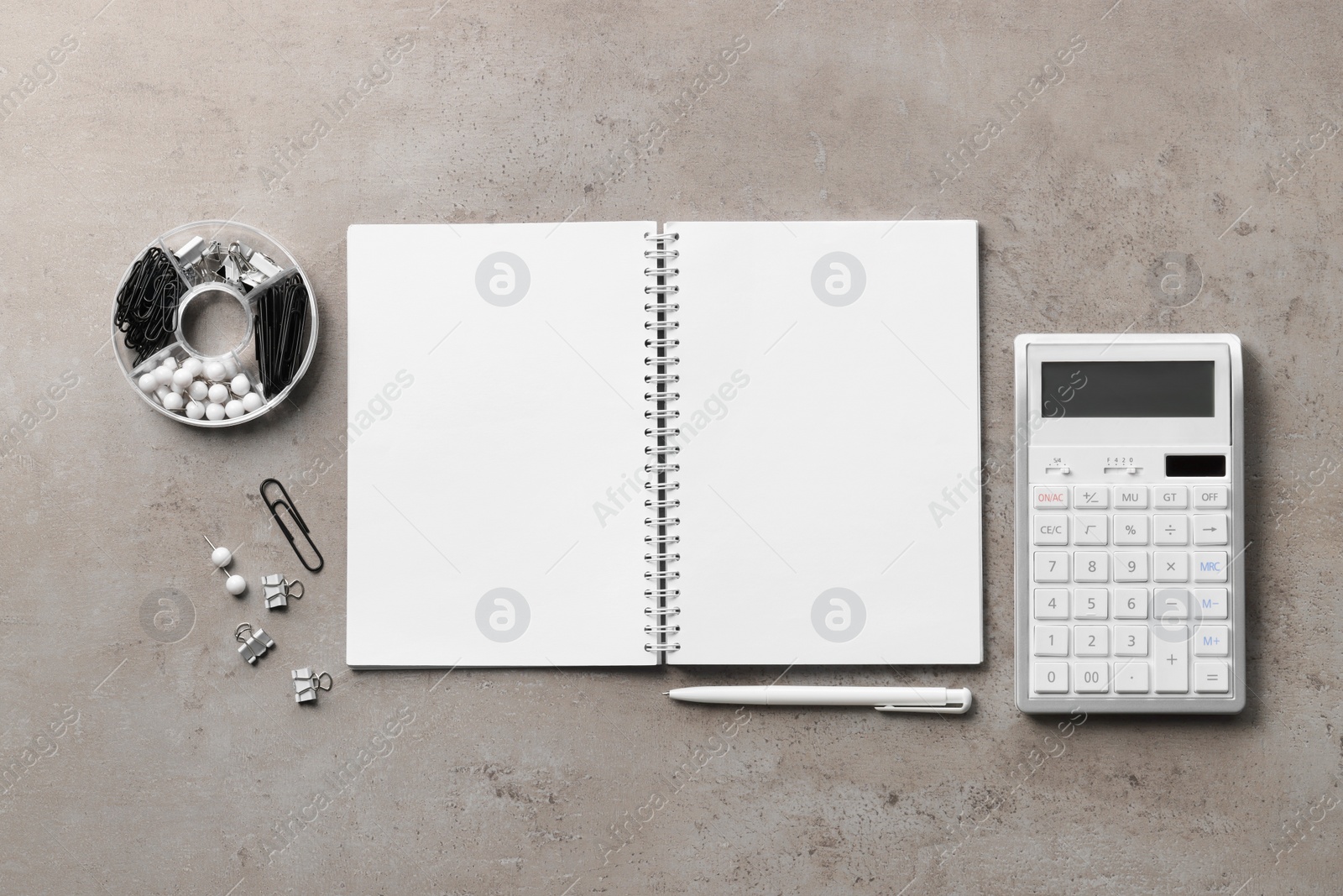 Photo of Ballpoint pen, notebook and calculator on gray table, flat lay